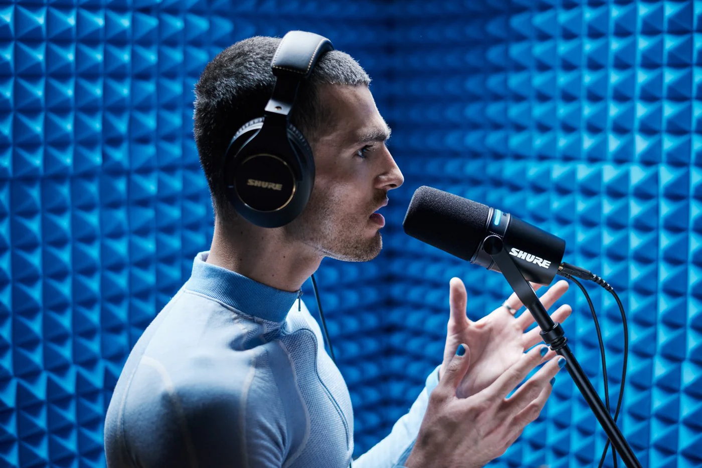 Shure MV7+ podcast mikrofonu ile kayıt yapan kişi
