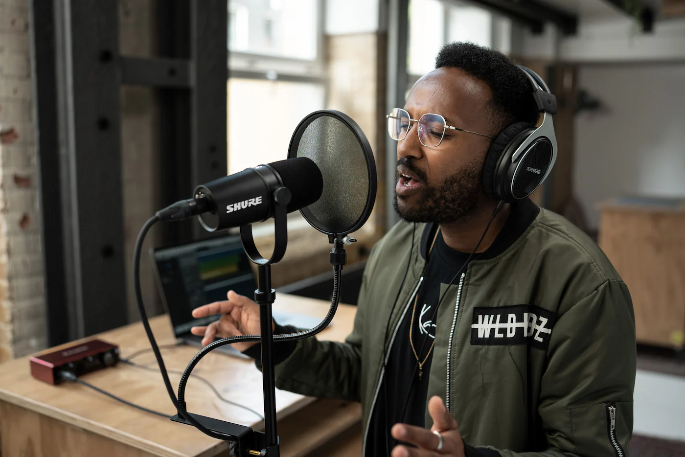 Shure MV7X podcast mikrofonu ile yayın yapan kişi