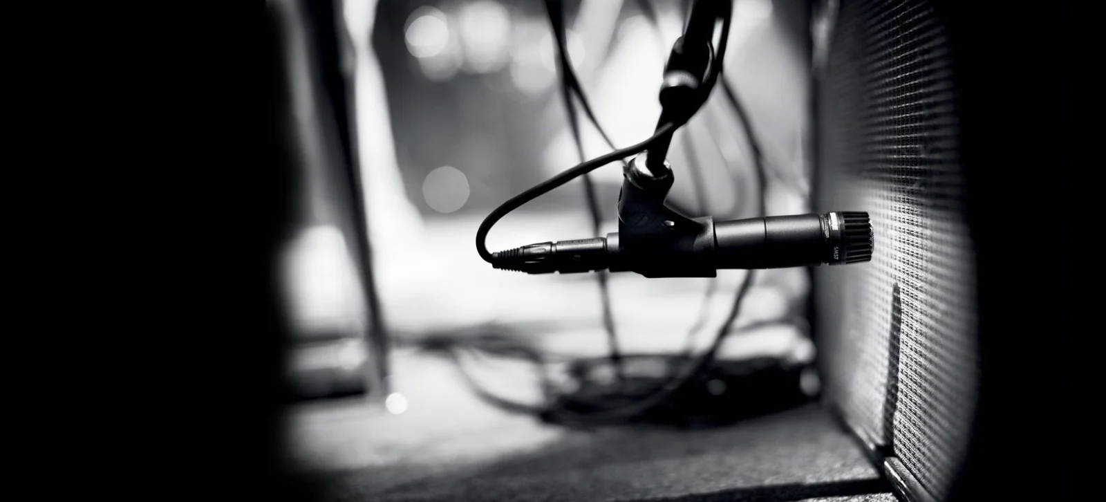 Shure SM57 enstrüman mikrofonu sahnede gitar amfisi önünde